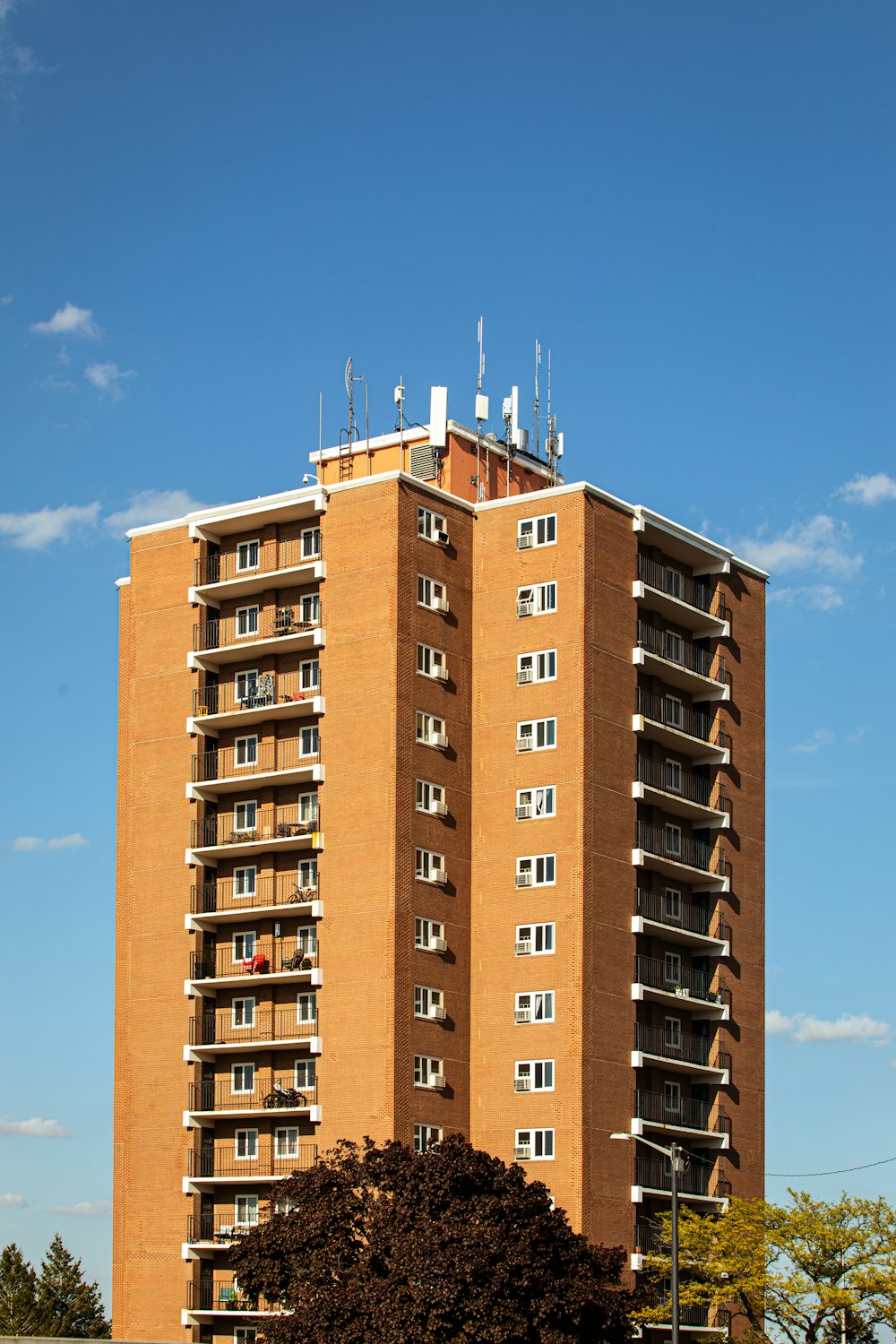 a tall brick building sitting next to a lush green field