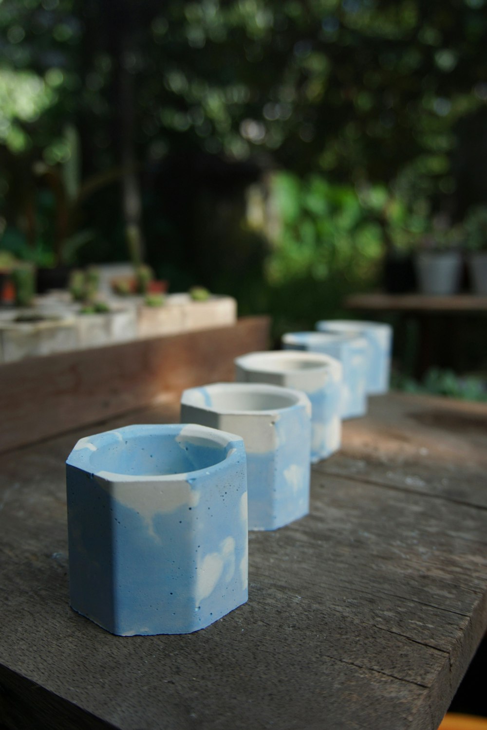 a row of blue vases sitting on top of a wooden table