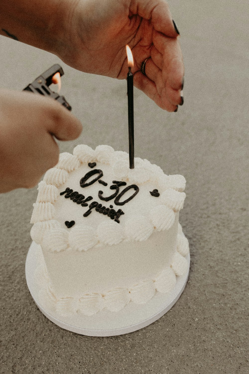 a person lighting a candle on top of a cake