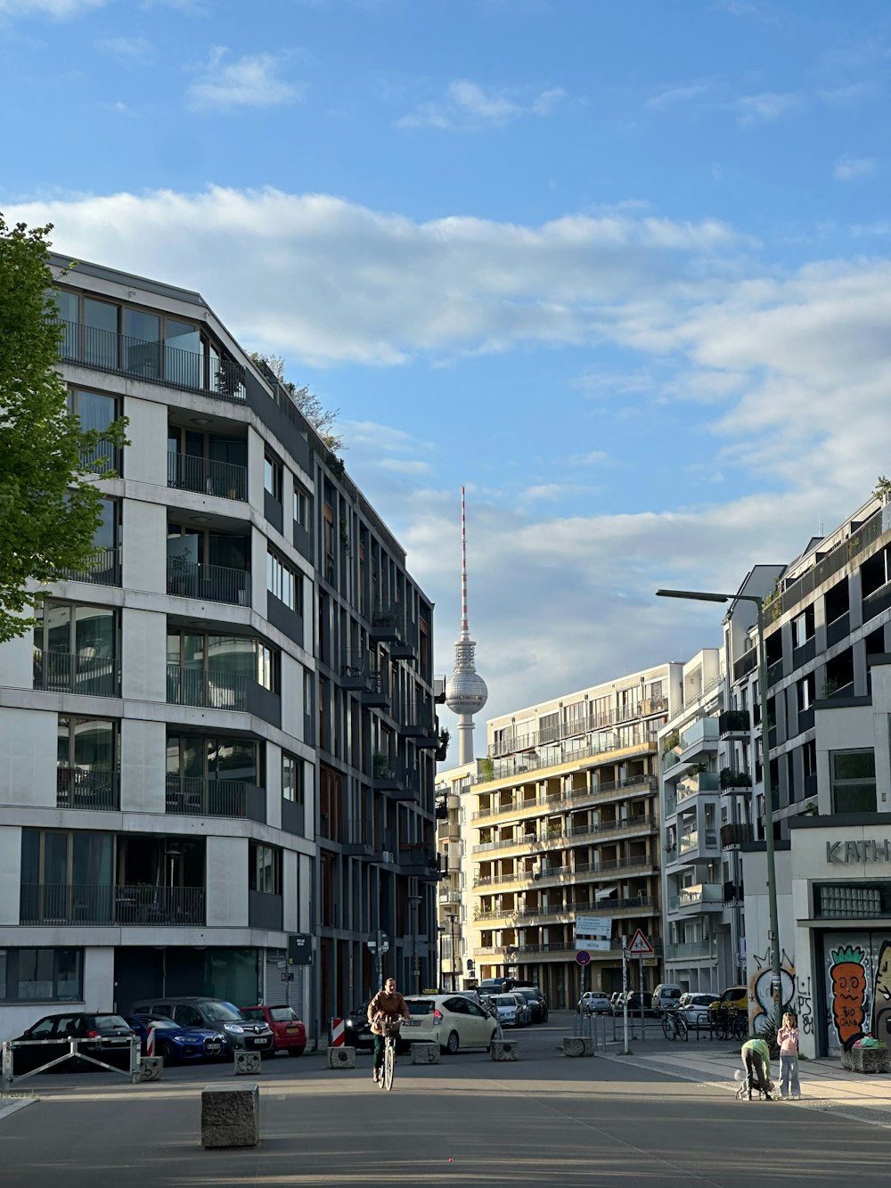 Un par de personas caminando por una calle junto a edificios altos