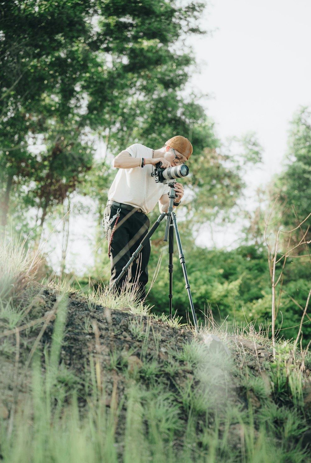 a man standing on top of a lush green hillside