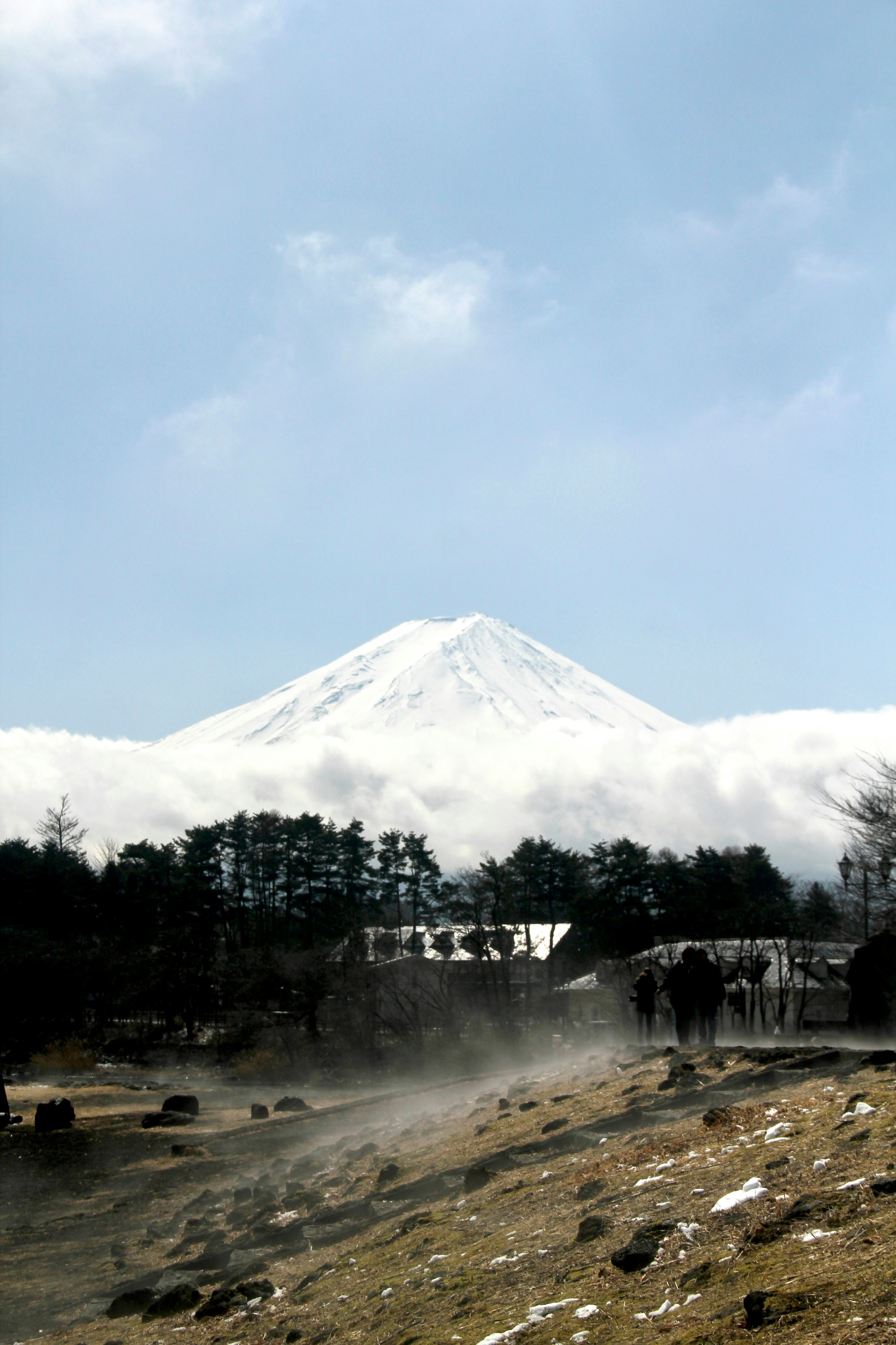 a group of people standing in front of a snow covered mountain