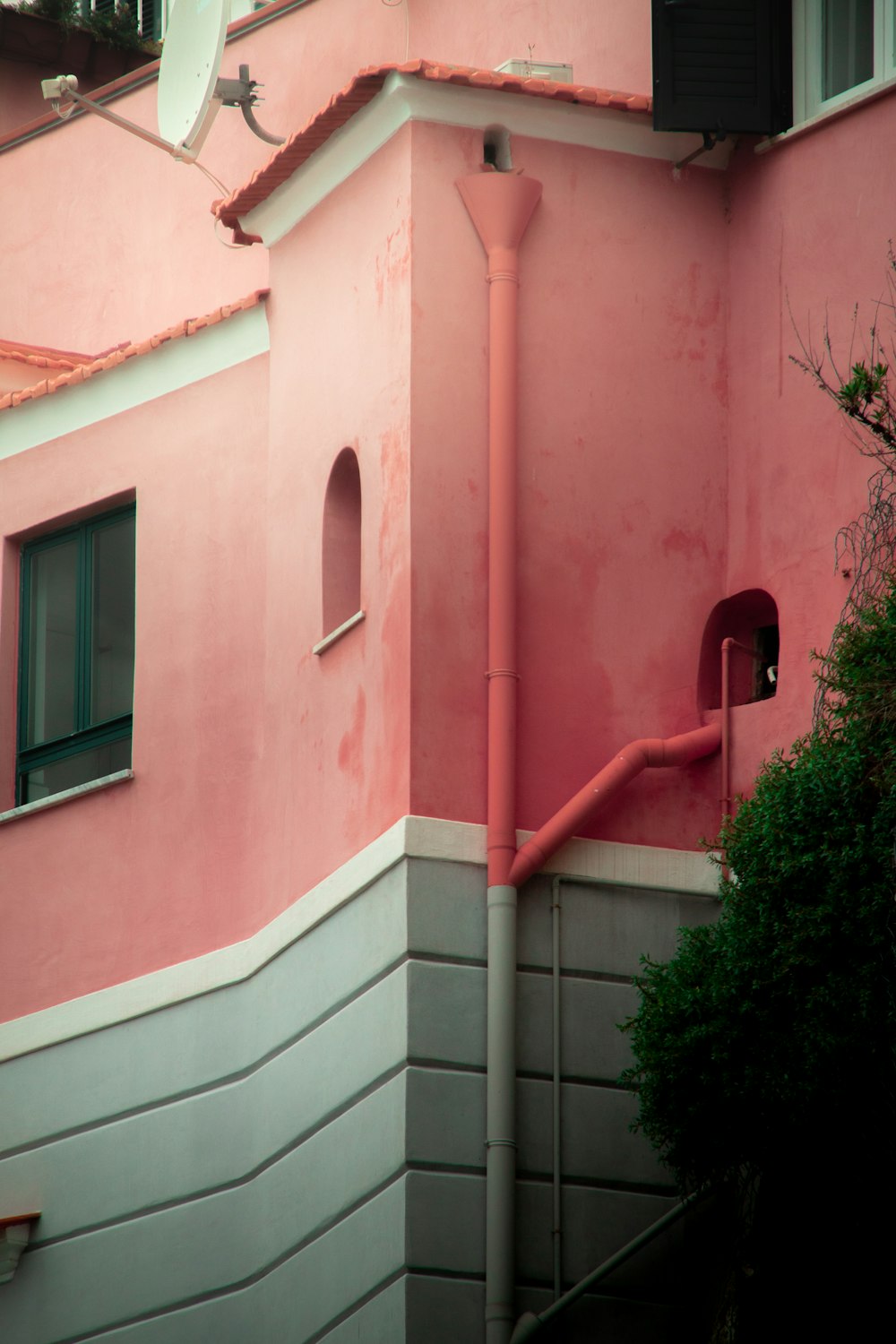 a pink building with a red pipe on the side of it
