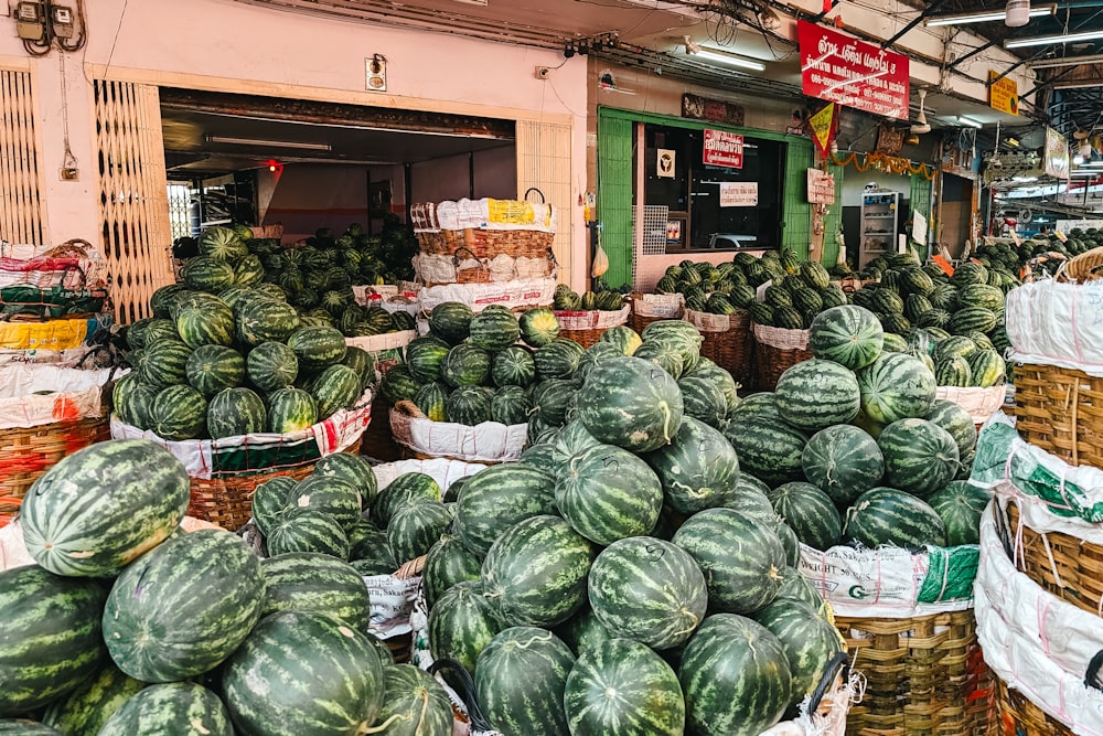 a market filled with lots of watermelons and other produce
