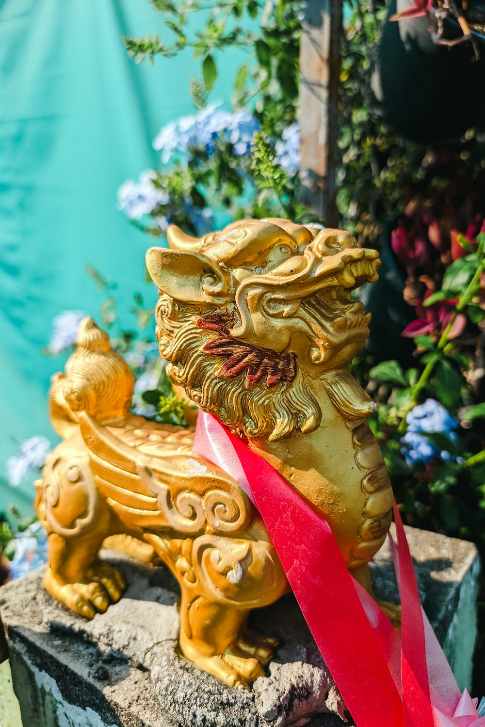 a statue of a golden lion with a red ribbon