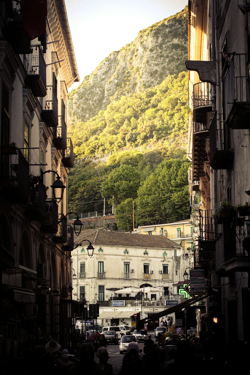 una calle de la ciudad con una montaña al fondo
