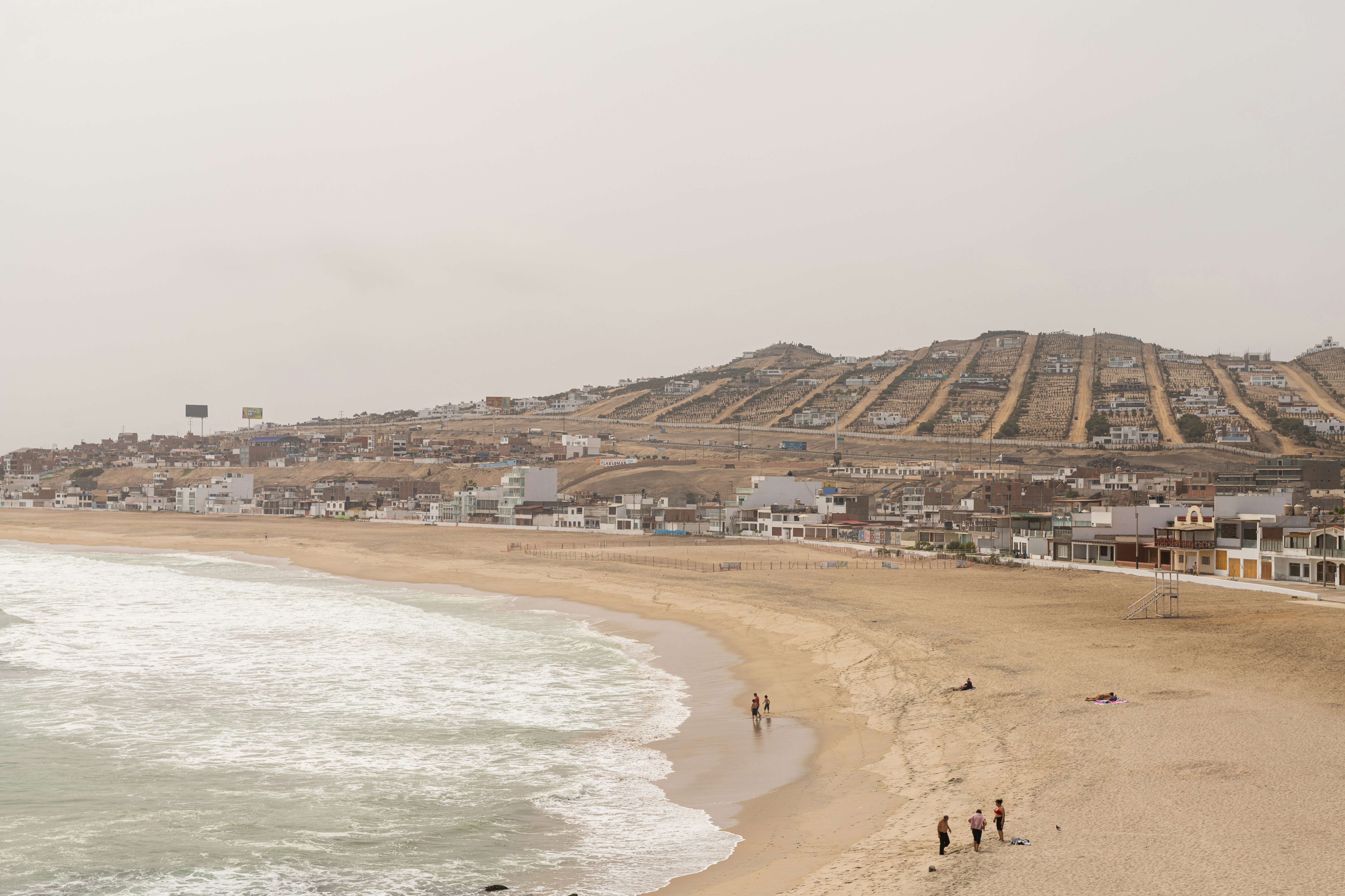 a group of people standing on top of a sandy beach