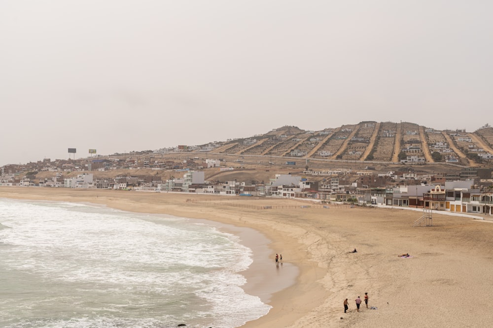 a group of people standing on top of a sandy beach