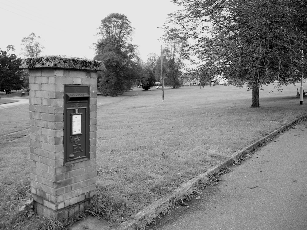a black and white photo of a mailbox in a park