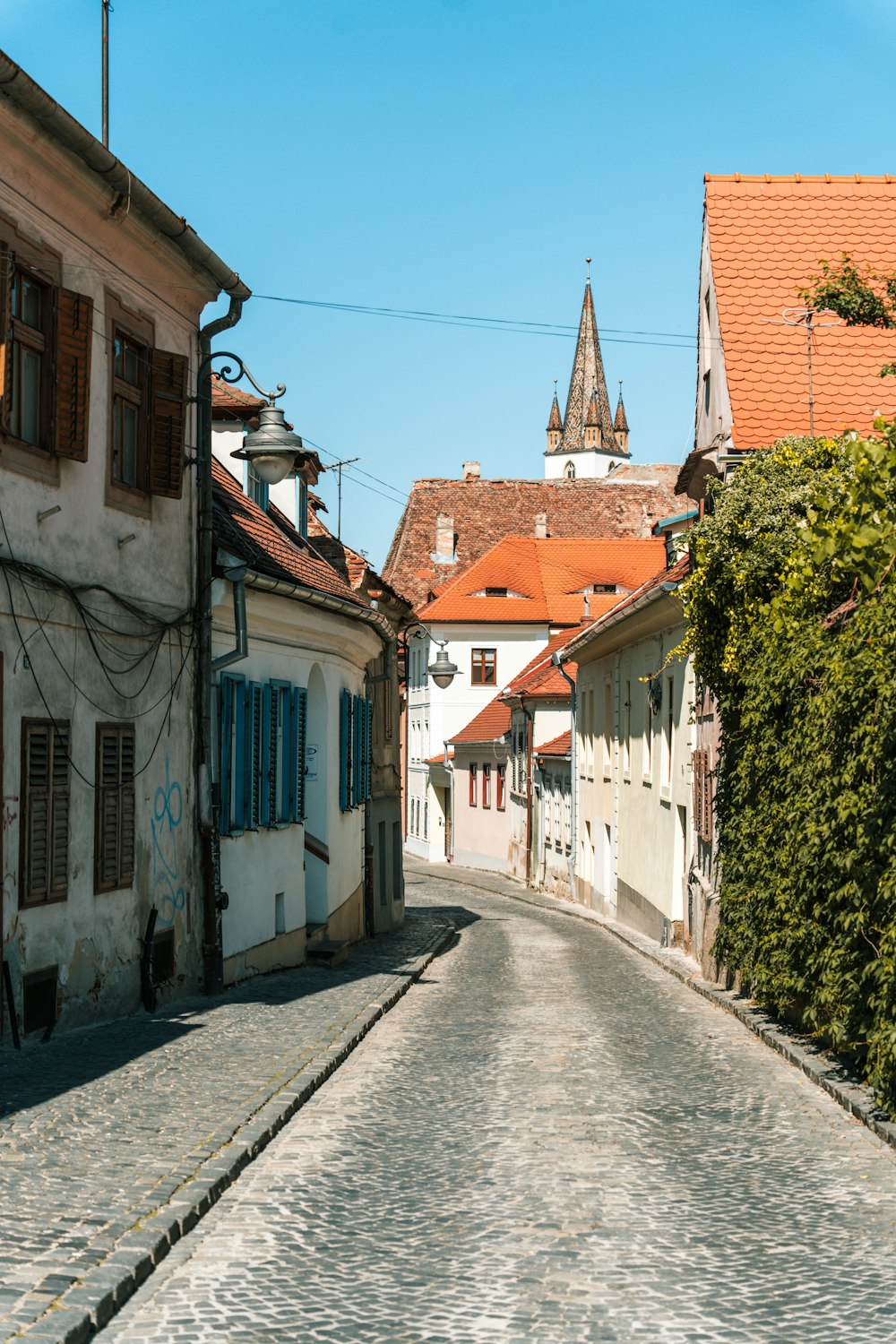 a cobblestone street with a clock tower in the background