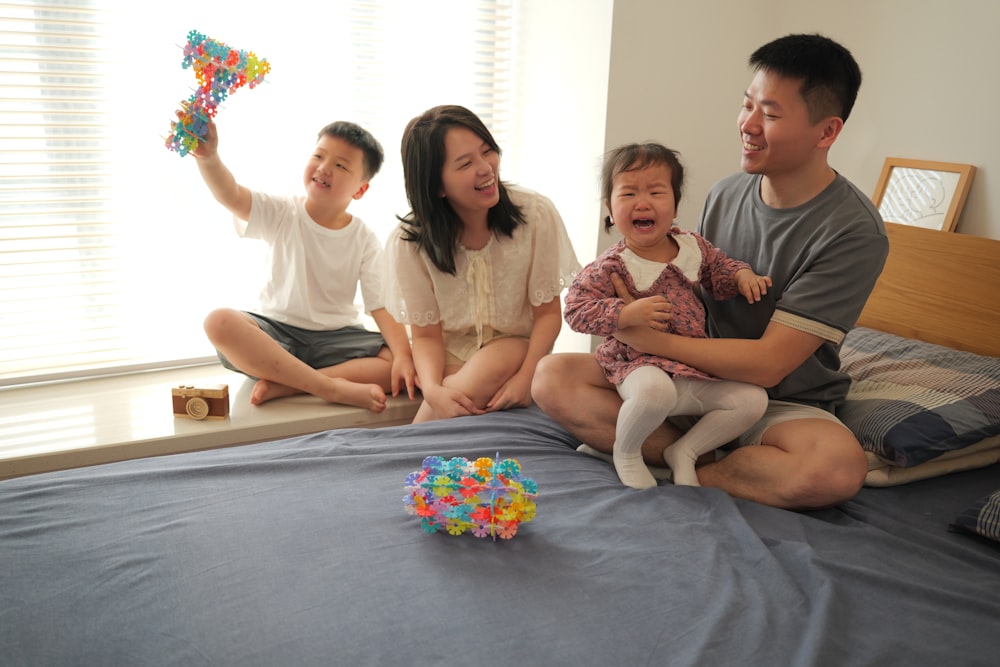 a group of people sitting on a bed together