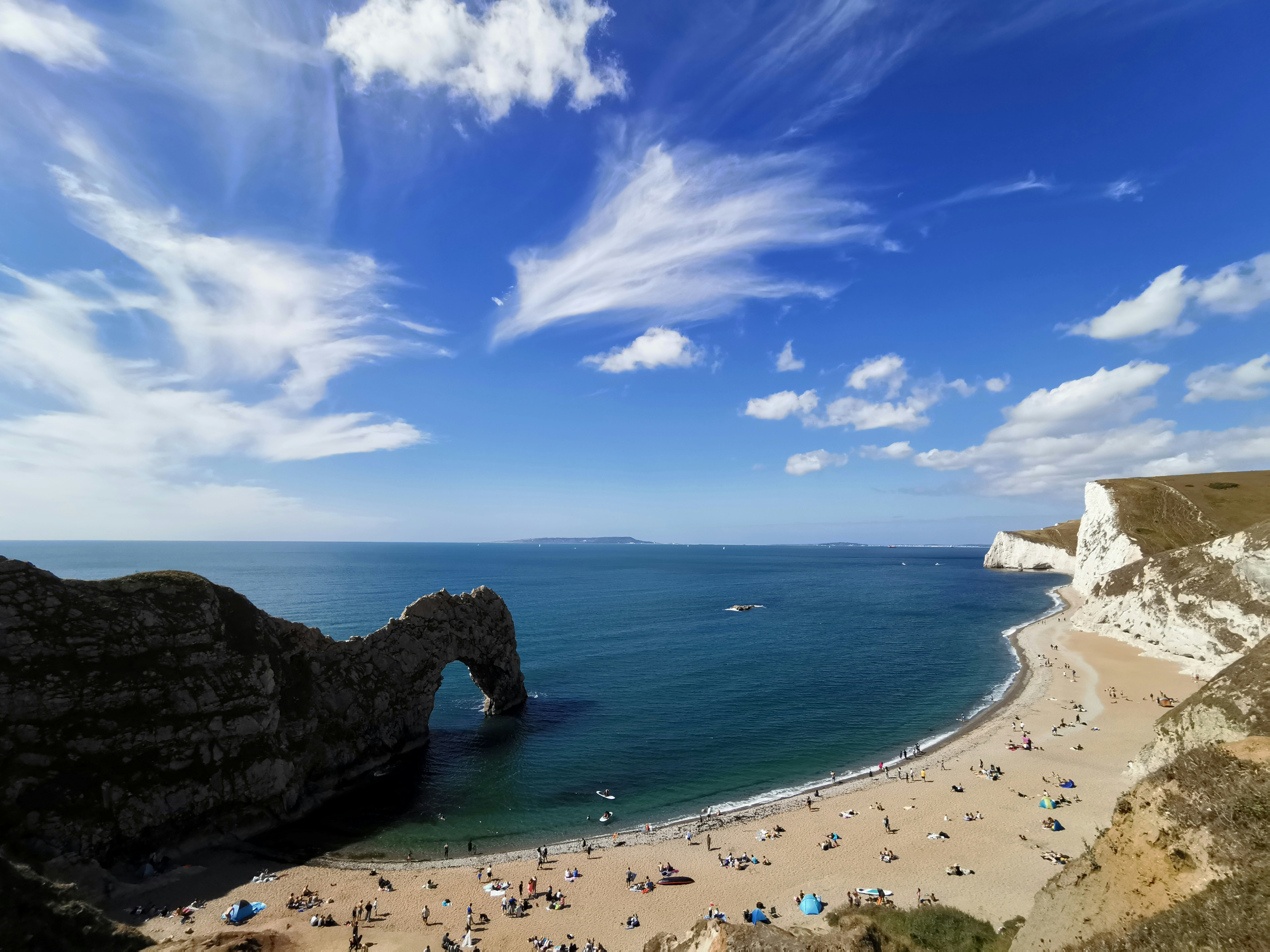 a view of a beach with people on it, Coastline trails in England