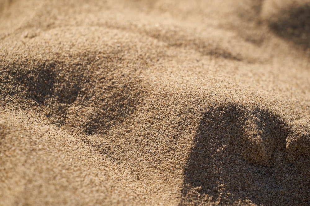a shadow of a person's foot in the sand