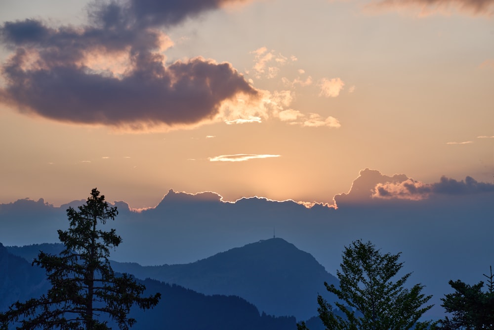 the sun is setting over a mountain range