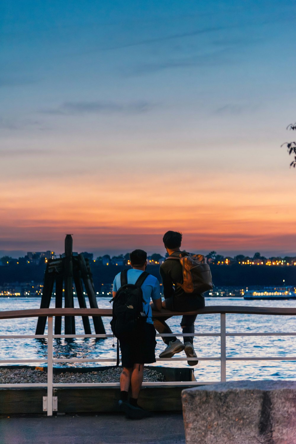 a couple of people standing on top of a pier