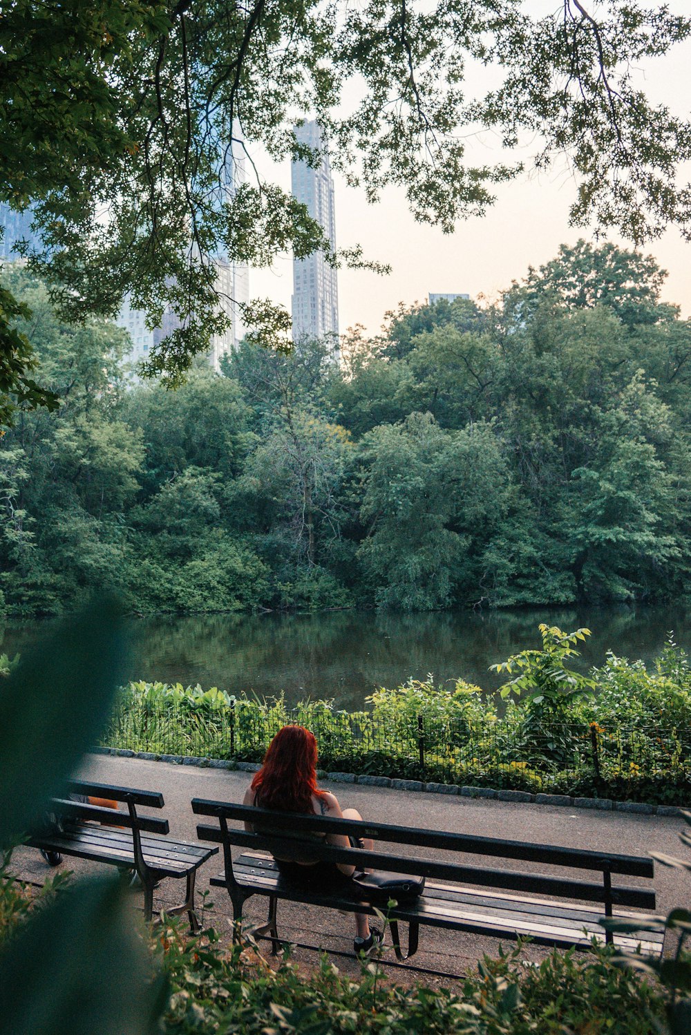 a woman sitting on a bench in a park