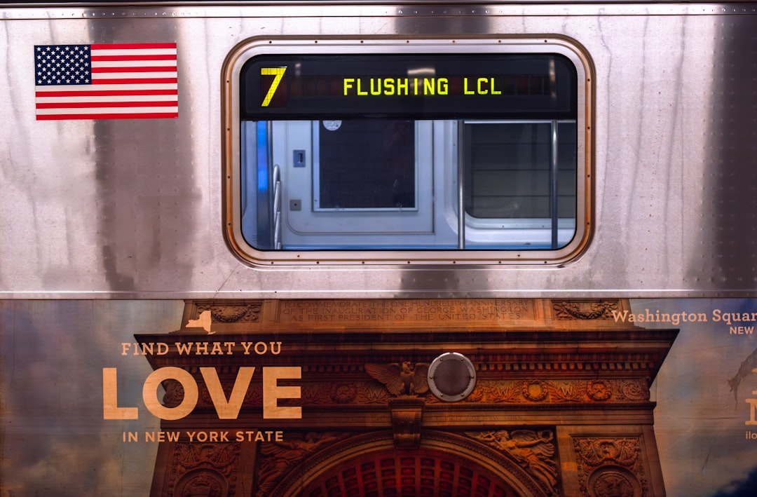 a silver train with a love sign on it, Flushing Local Train at Hudson Yards Subway Station