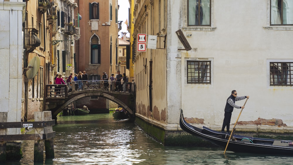 a man riding a gondola down a narrow street