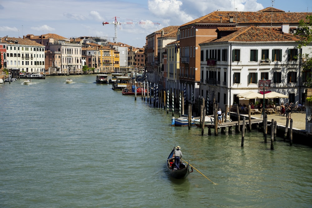 a boat traveling down a river next to tall buildings