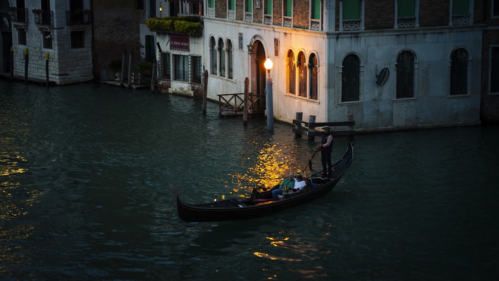 a gondola in a canal with a building in the background