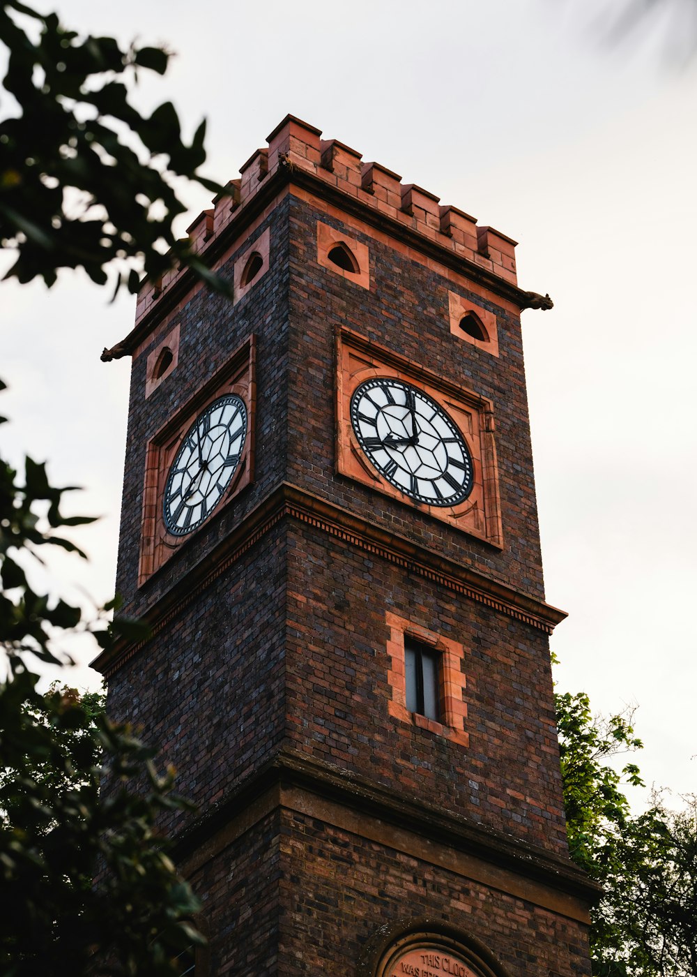 a tall brick clock tower with a clock on each of it's sides