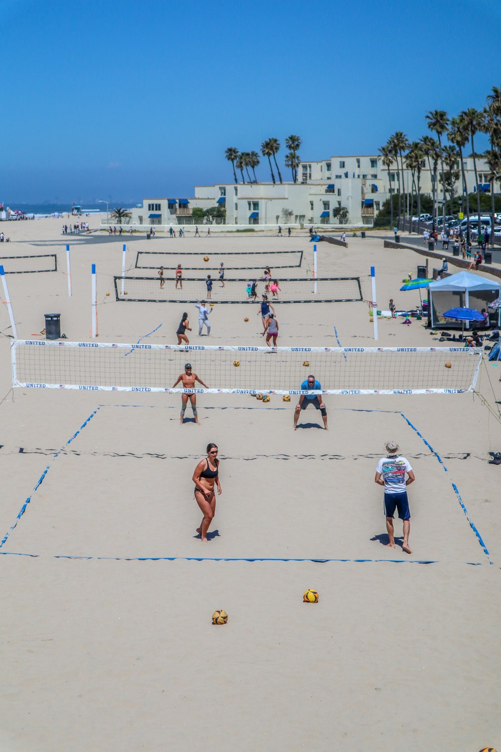 a group of people playing volleyball on a beach