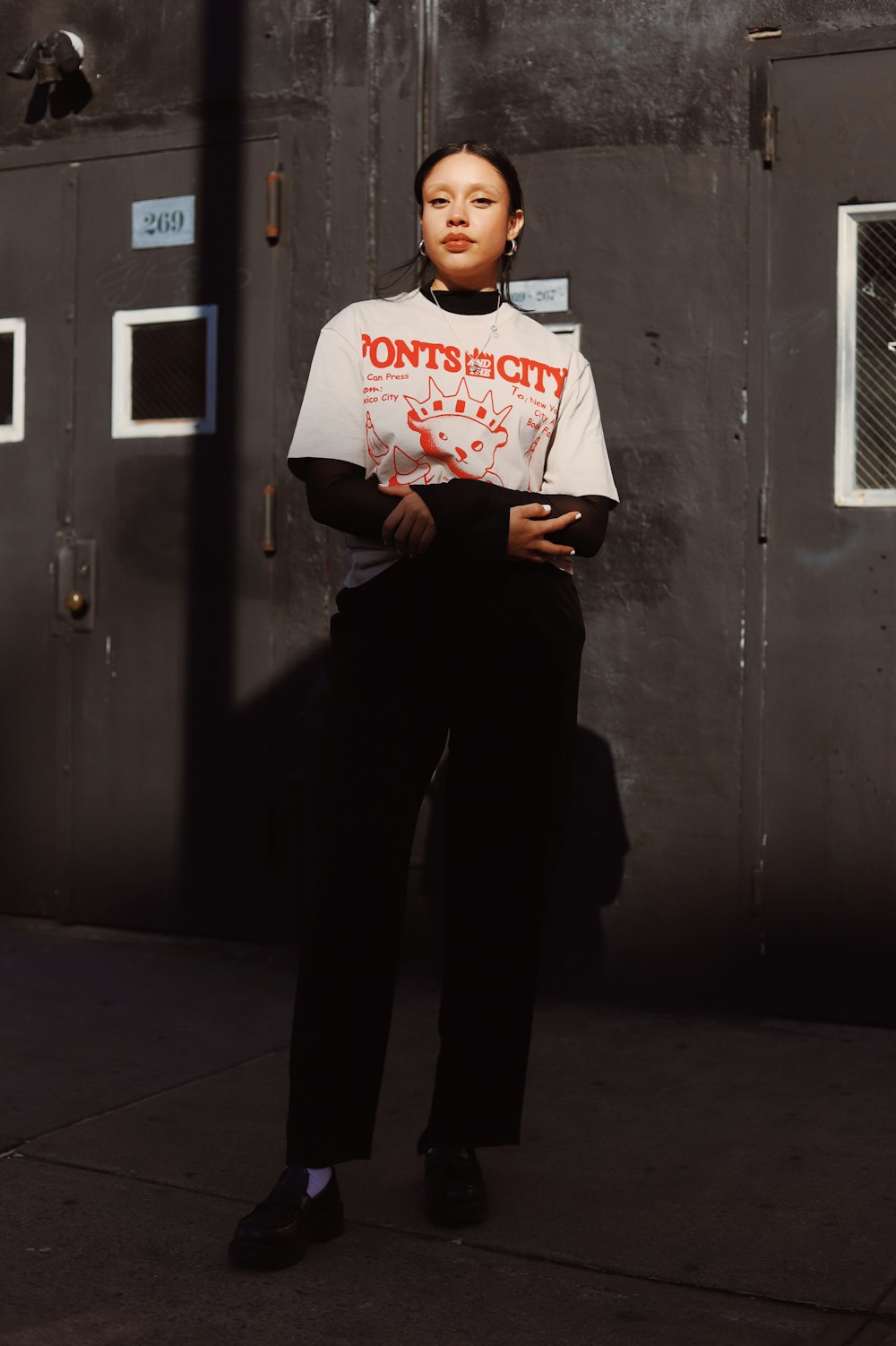 a woman standing in front of a metal door