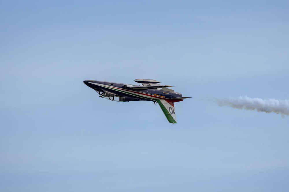 a small plane flying in the air with a smoke trail behind it