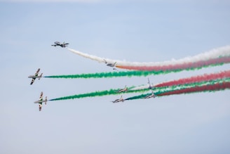 a group of airplanes flying through a blue sky