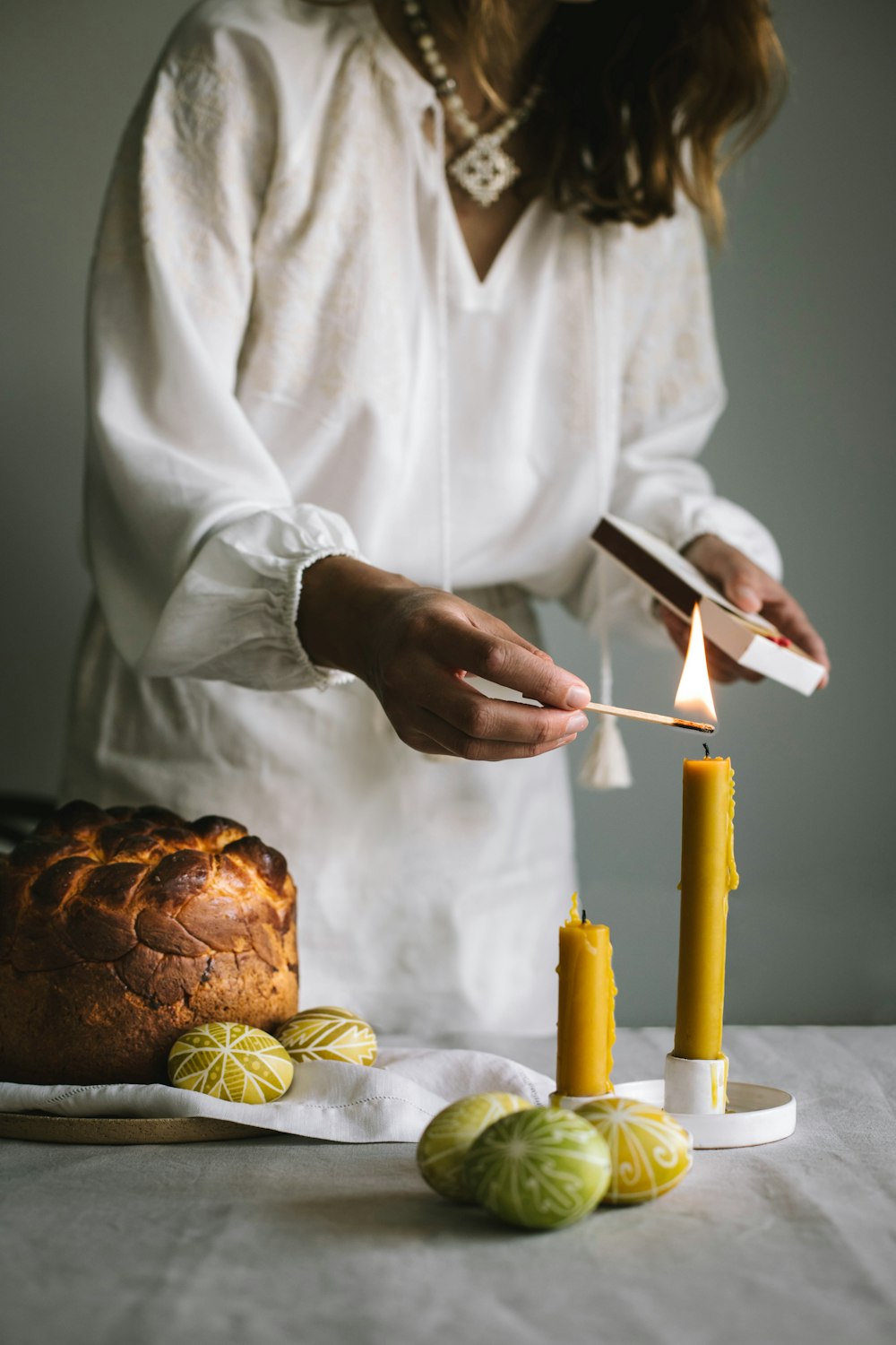 a woman lighting a candle on top of a cake