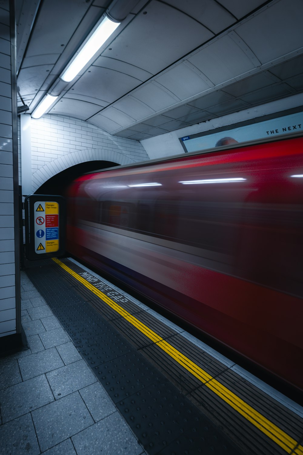 a red train traveling through a subway station