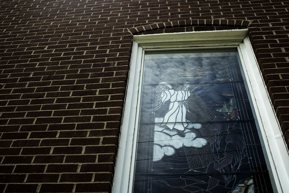 a stained glass window on the side of a brick building