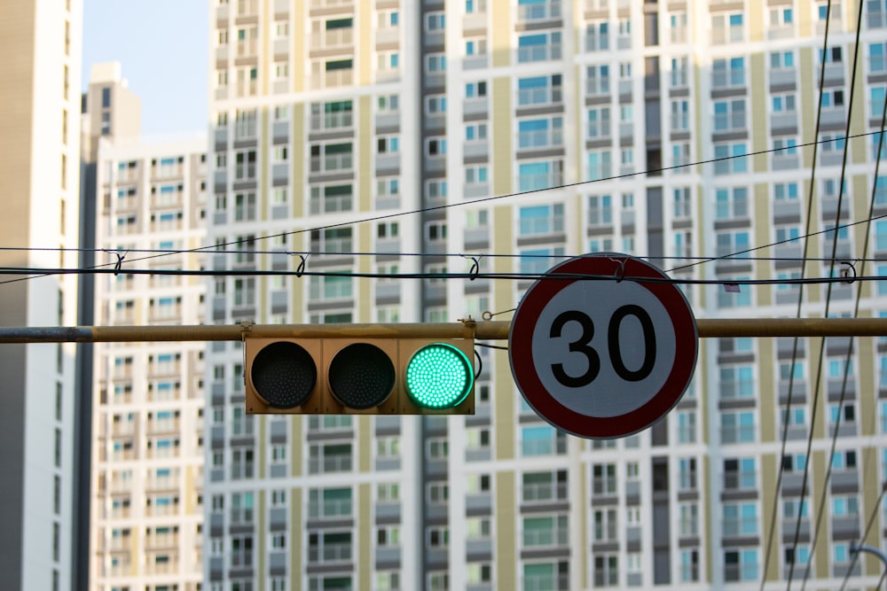 a traffic light hanging from a wire next to a tall building