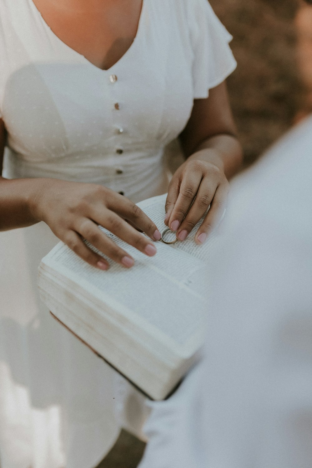 a woman in a white shirt is holding a book