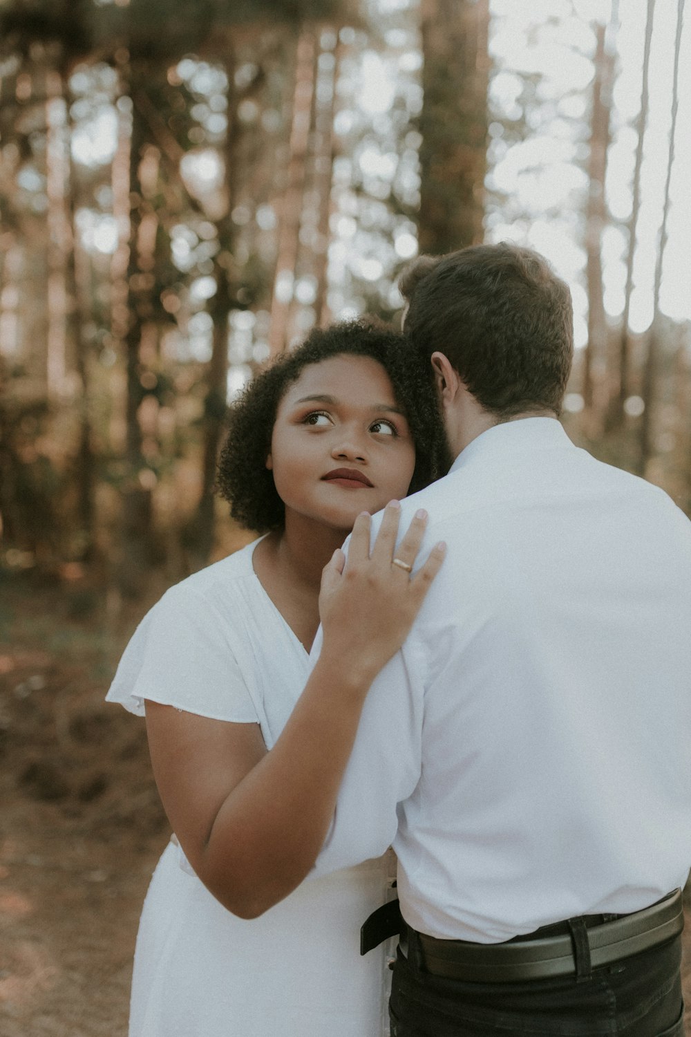 a man and woman embracing in the woods