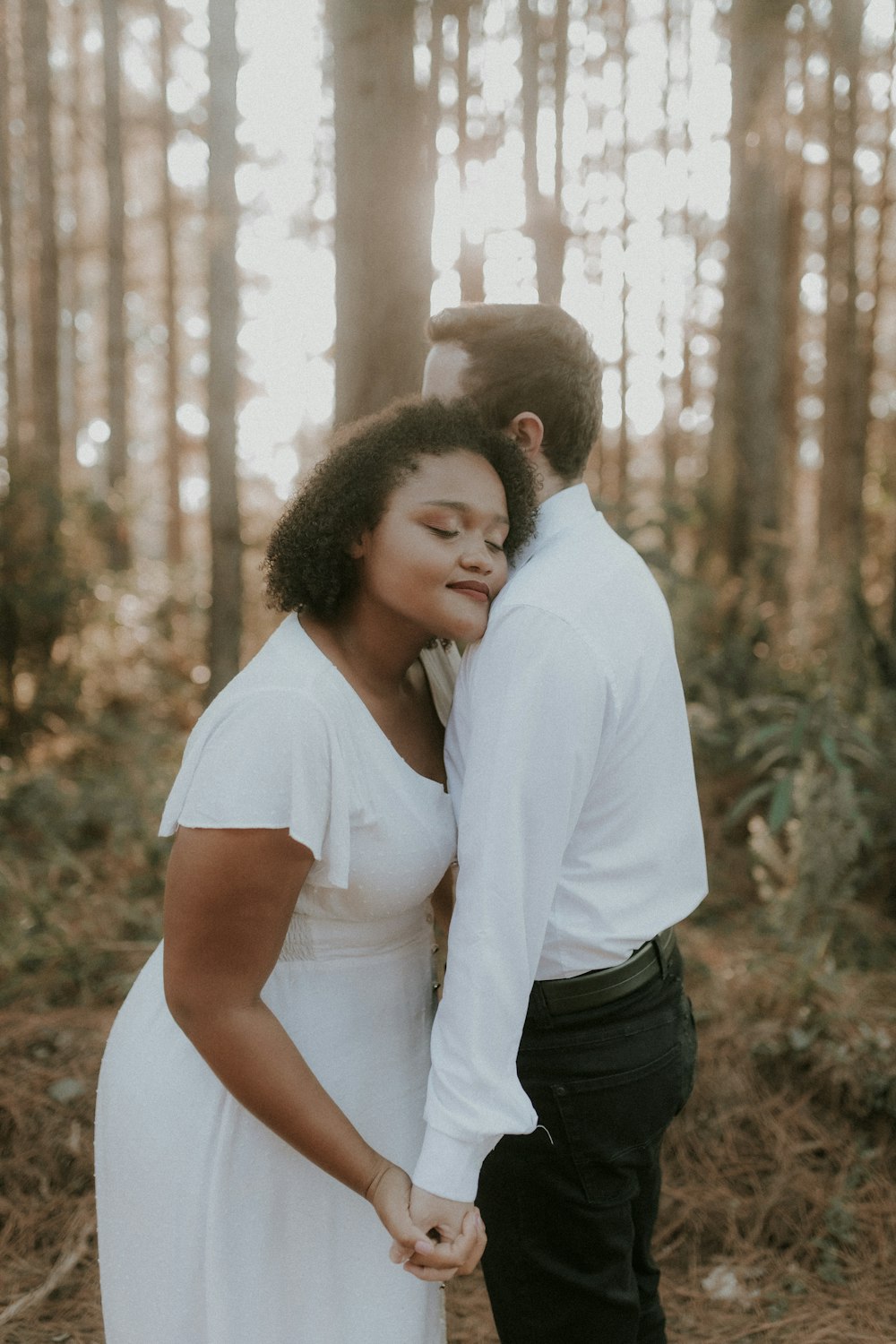 a man and a woman standing in the woods