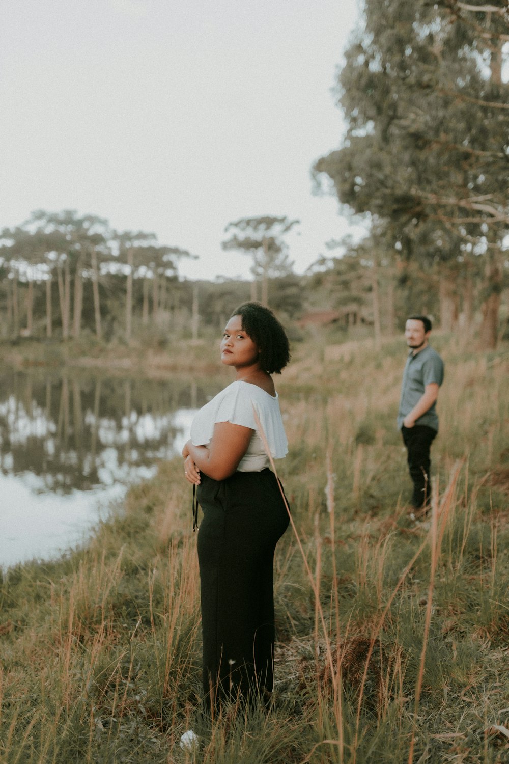 a man and a woman standing next to a body of water