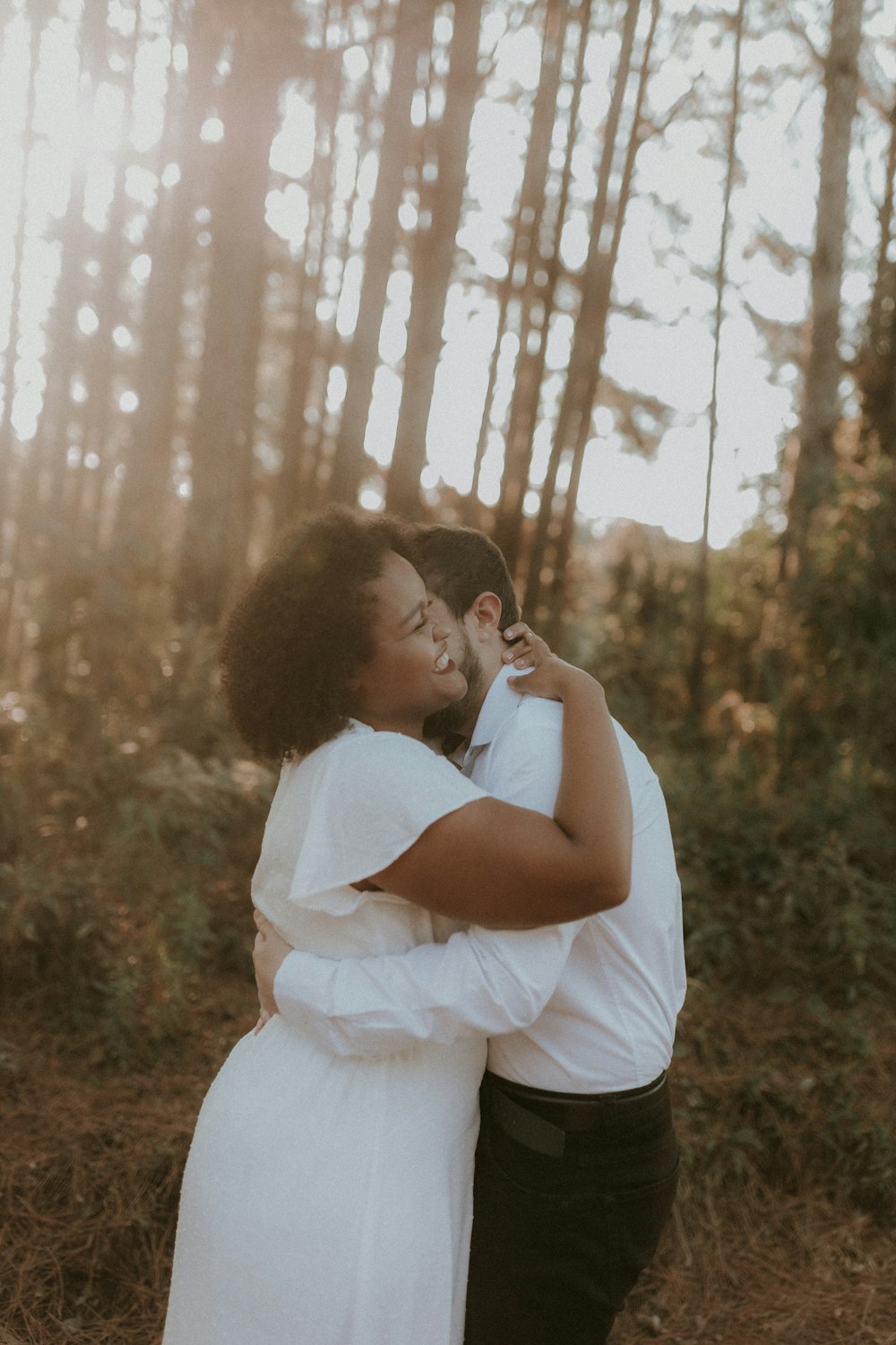 a man and woman embracing in the woods