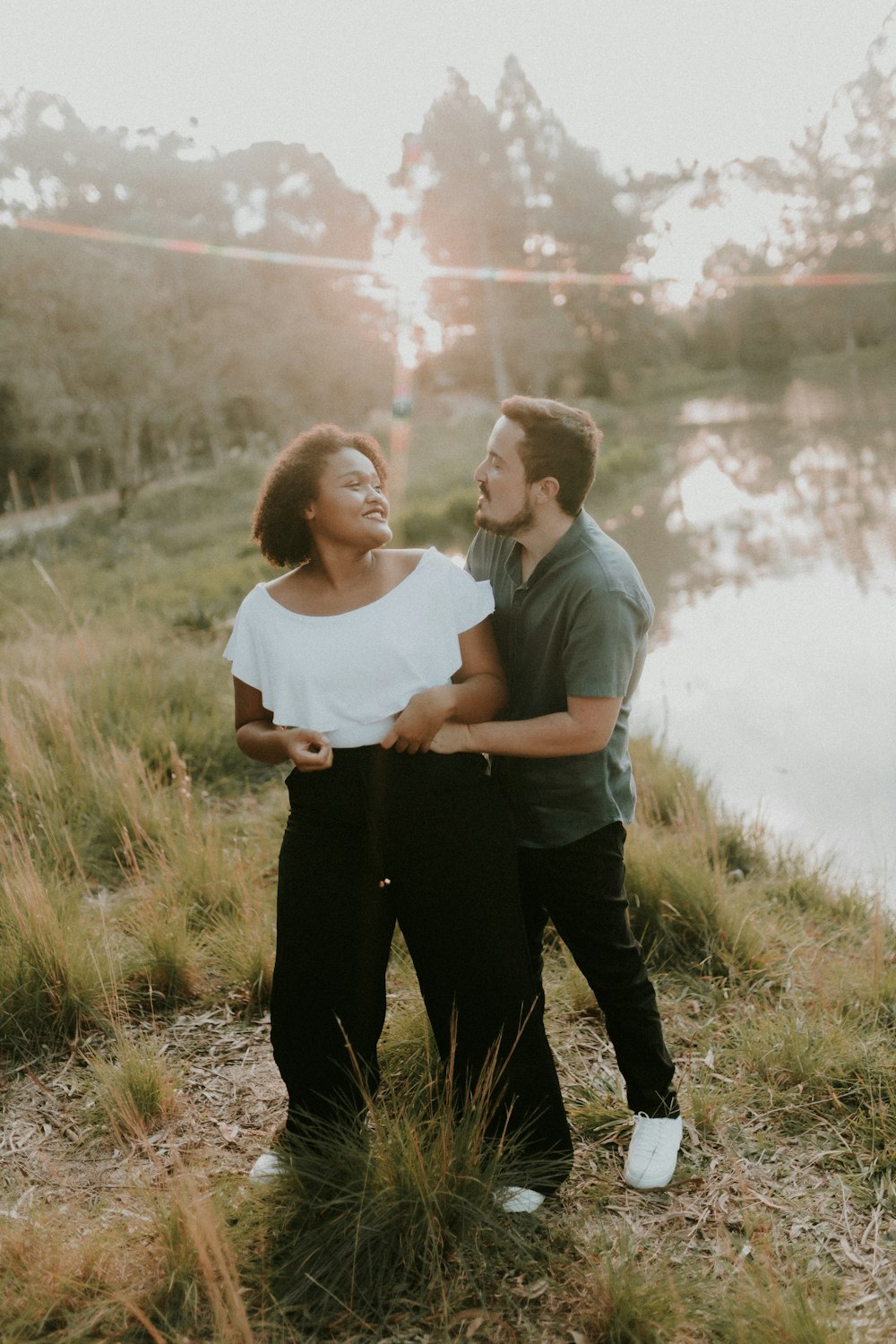 a man and a woman standing next to each other near a body of water