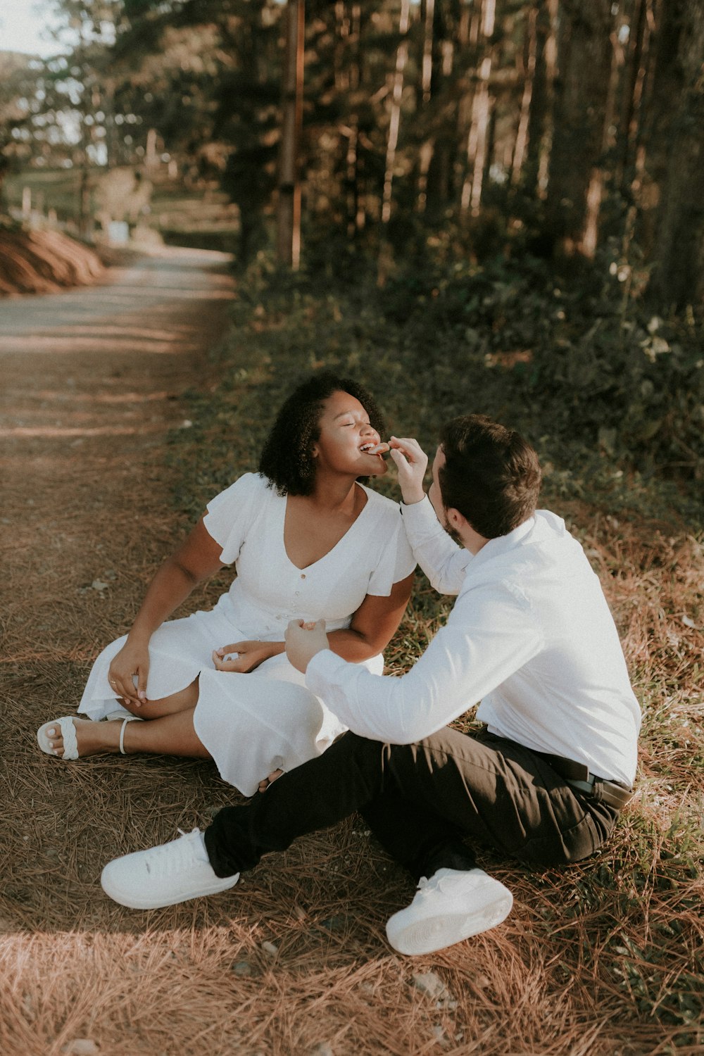 a man feeding a woman a piece of cake