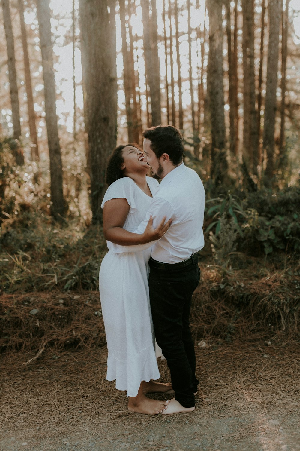 a man and woman kissing in the woods