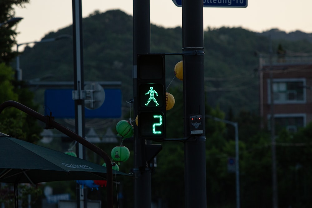 緑��色の歩行者標識が付いた信号機