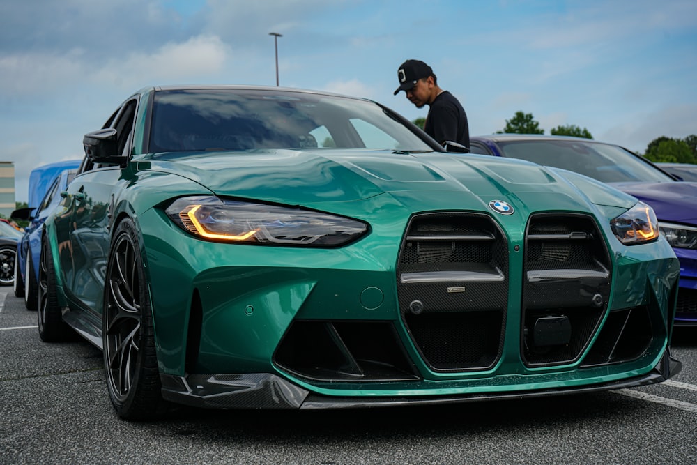 a man standing next to a green sports car