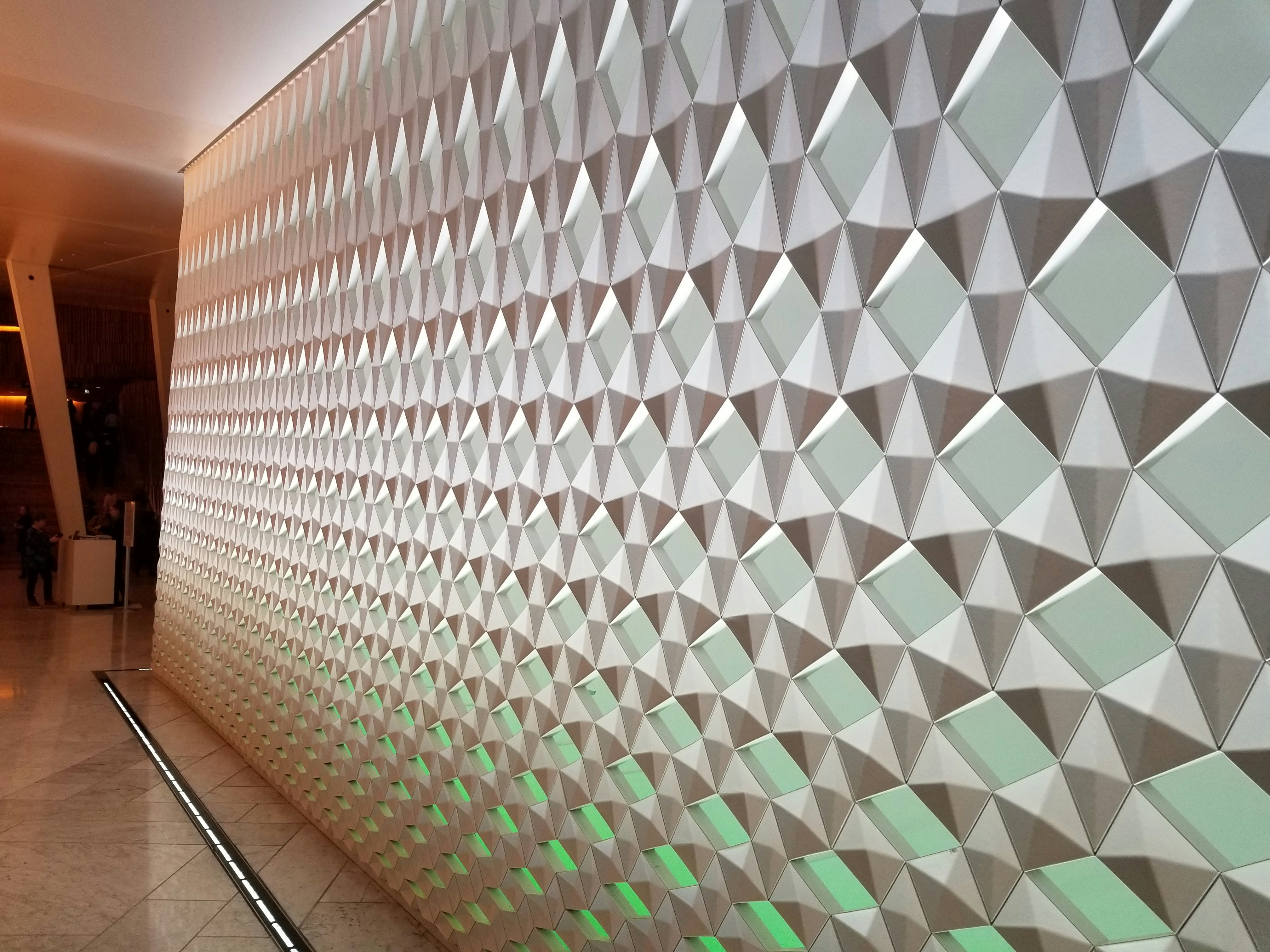 Luxuriously textured velvet-finish wall in deep green, designer apartment India, moody lighting