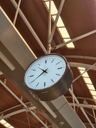 a clock hanging from the ceiling of a building