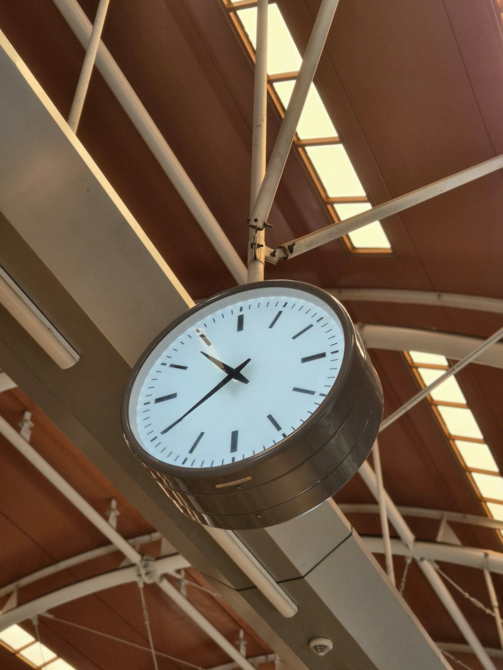 a clock hanging from the ceiling of a building