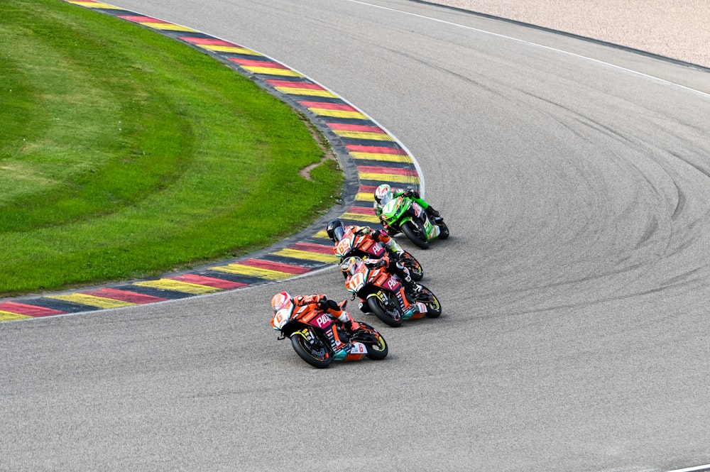 a group of people riding motorcycles on a race track