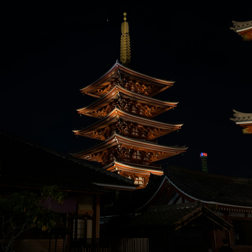 a tall building lit up at night with a sky background