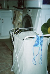 a laundry basket with a teddy bear sitting on top of it