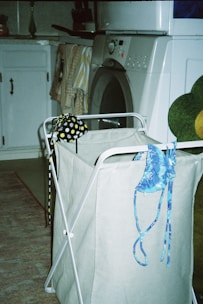 a laundry basket with a teddy bear sitting on top of it
